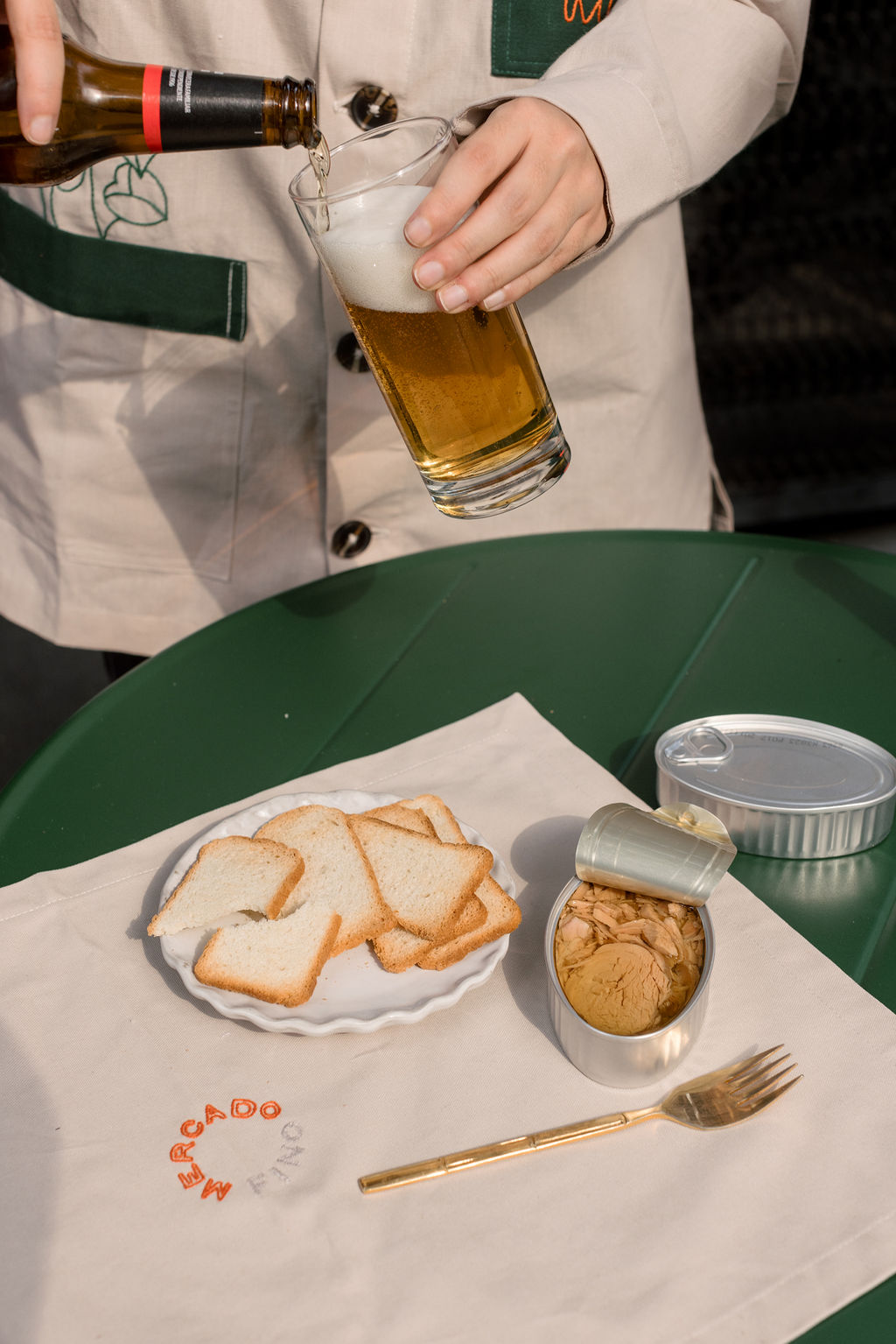 Servicio de cerveza junto a una mesa de conservas